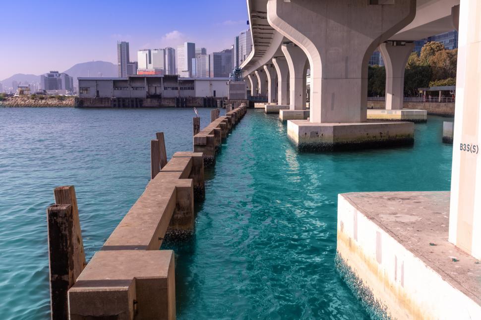 Free Image of Urban Bridge Over River With Cityscape in Background 
