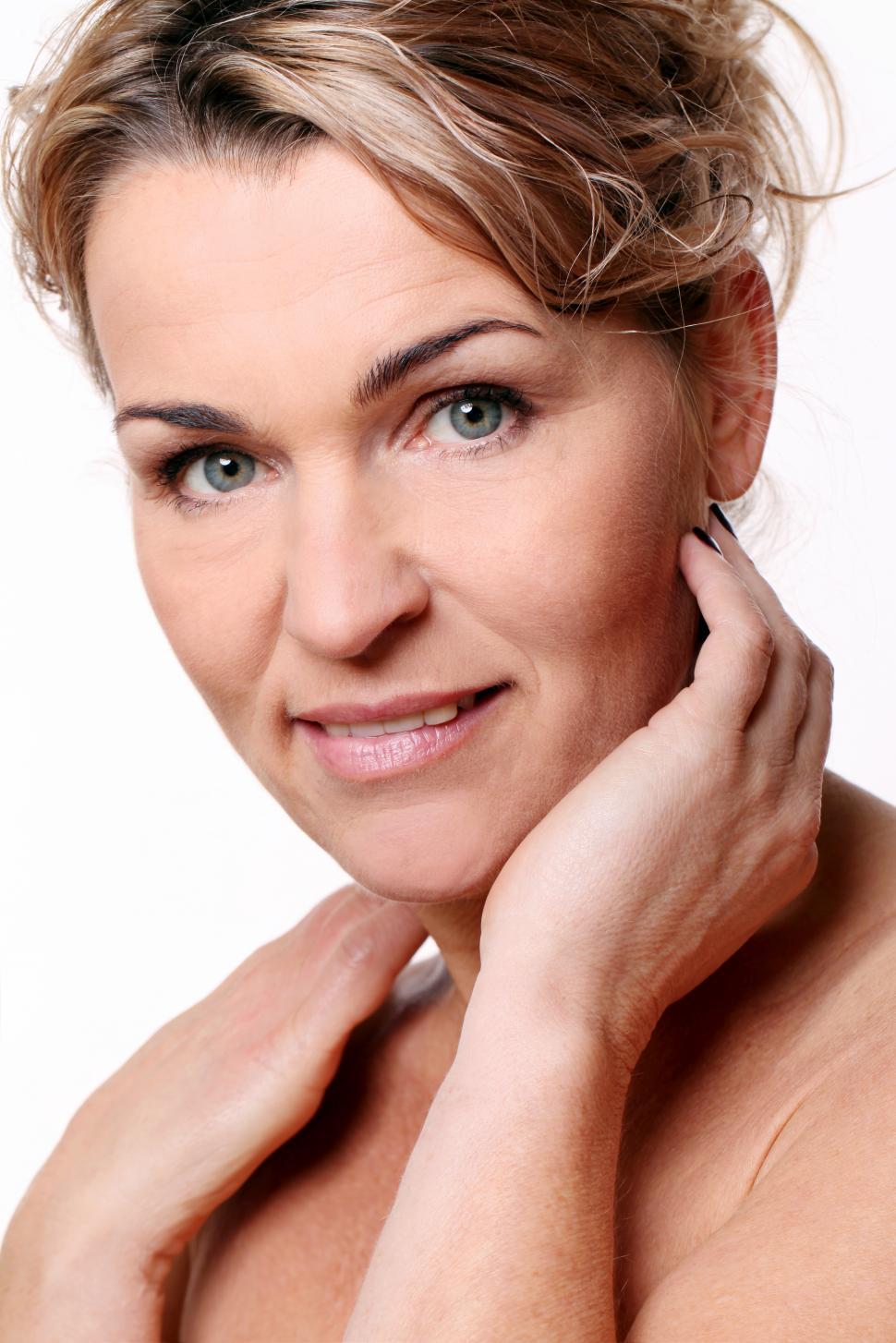 Free Image of Middle aged woman with hands at neck 