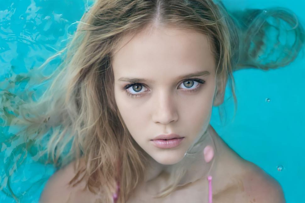 Free Image of Young Woman in Pink Bikini Top With Straw in Mouth 