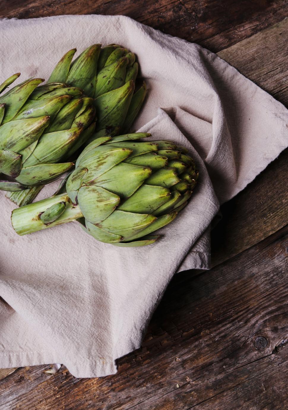 Free Image of Three Artichokes on natural fabric 