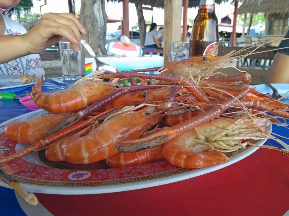 Free Image of Person eating cooked shrimps  