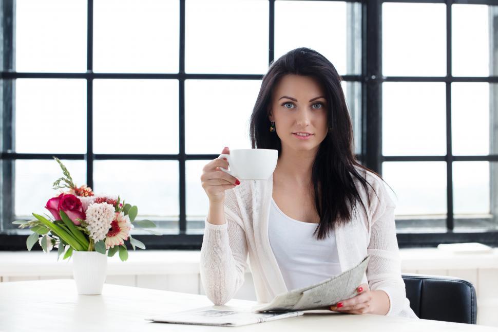 Free Image of Woman with a cup of coffee and morning newspaper 