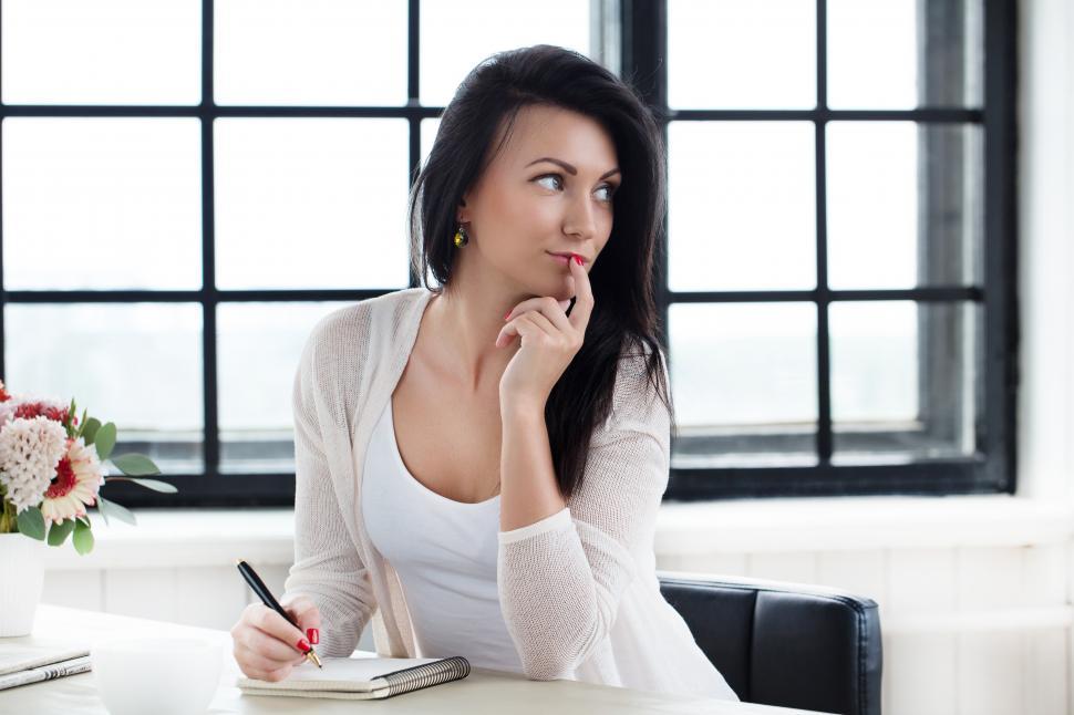 Free Image of Young woman at a desk, thinking  