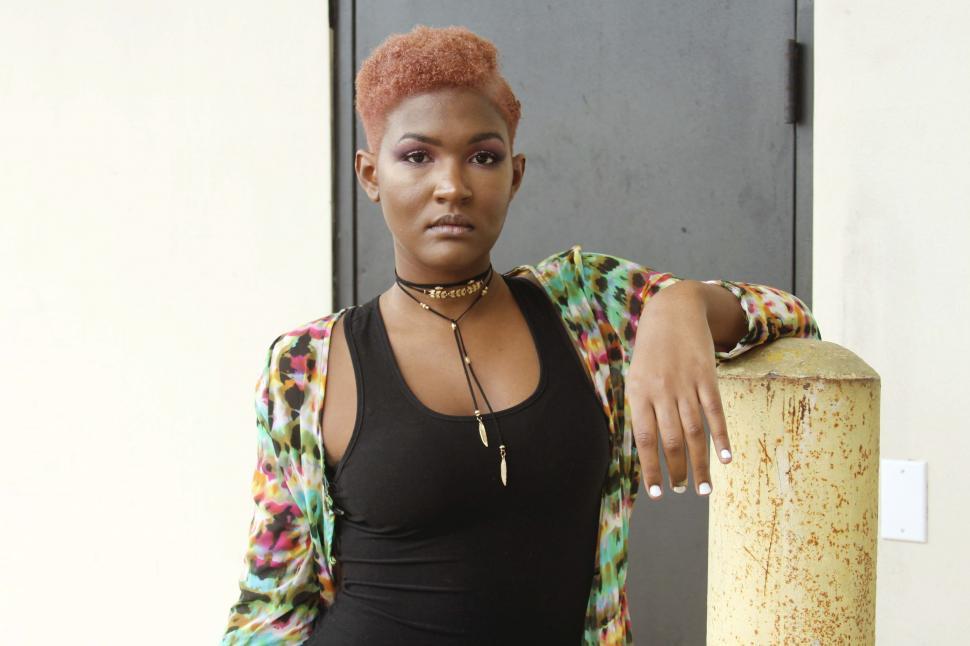 Free Image of Black woman in dark tank top with short red hair - looking at camera intensely 