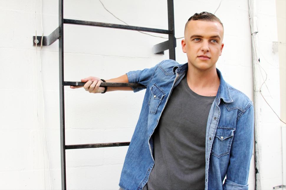 Free Image of Male fashion model posing with ladder 