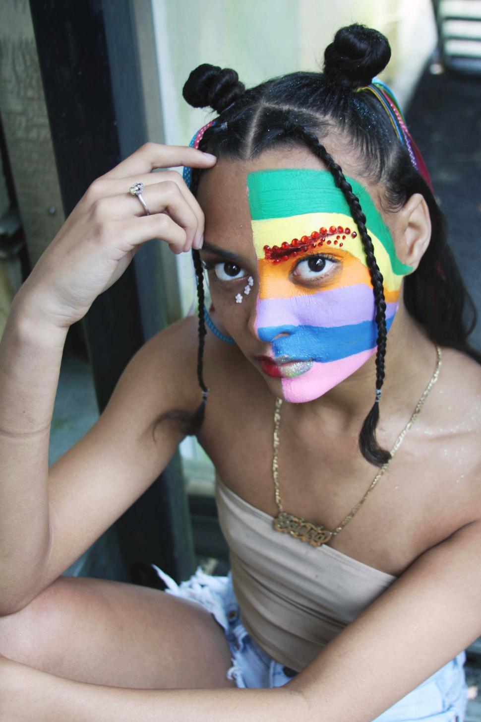 Free Image of Woman with face painted with LGBTQ flag rainbow color 