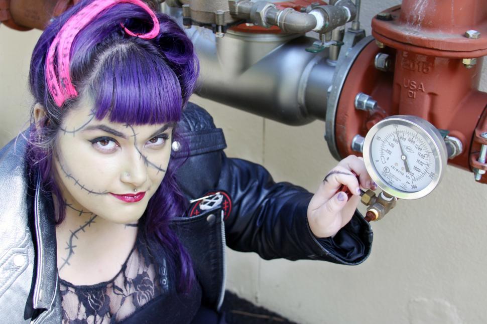 Free Image of Woman with halloween makeup, holding red fire extinguishing wate 