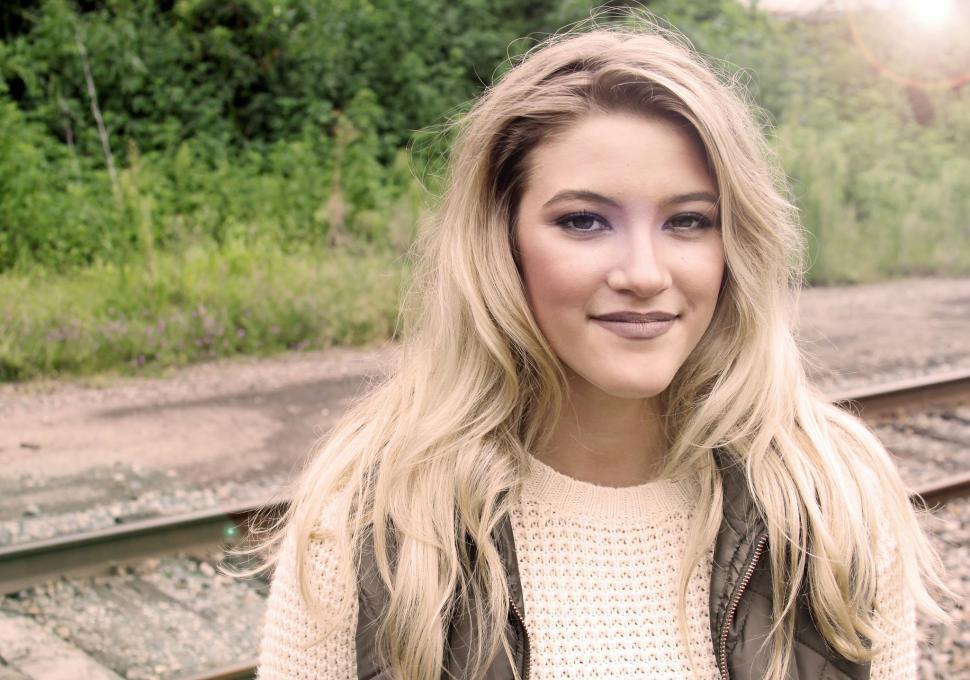 Free Image of Smiling teenage girl on rail track 