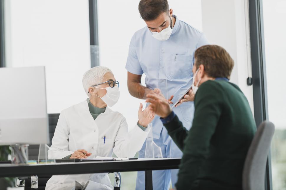 Free Image of Elderly female doctor and patient in clinic wearing face masks - 