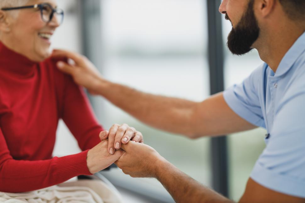 Free Image of Male caregiver talking to old-aged woman in wheelchair 