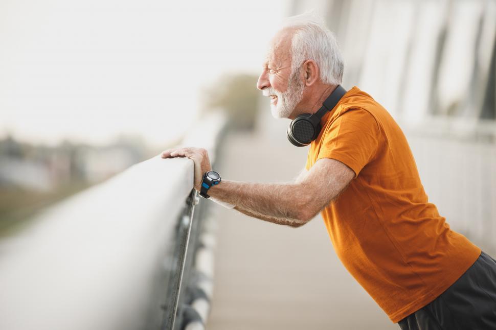 Free Image of Elderly man with headphones on his neck doing morning workout on 
