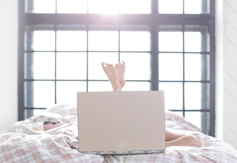 Free Image of Laptop in the bedroom, user barely visible 