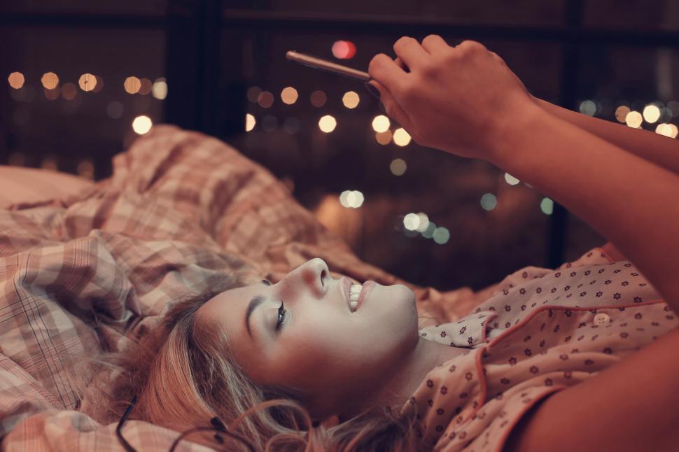 Free Image of Young woman illuminated by her phone screen 