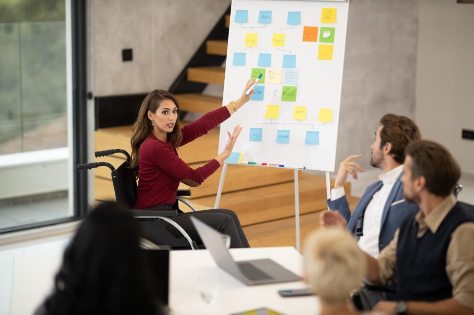 Free Image of Wheelchair-using woman with her co-workers during a meeting in office 