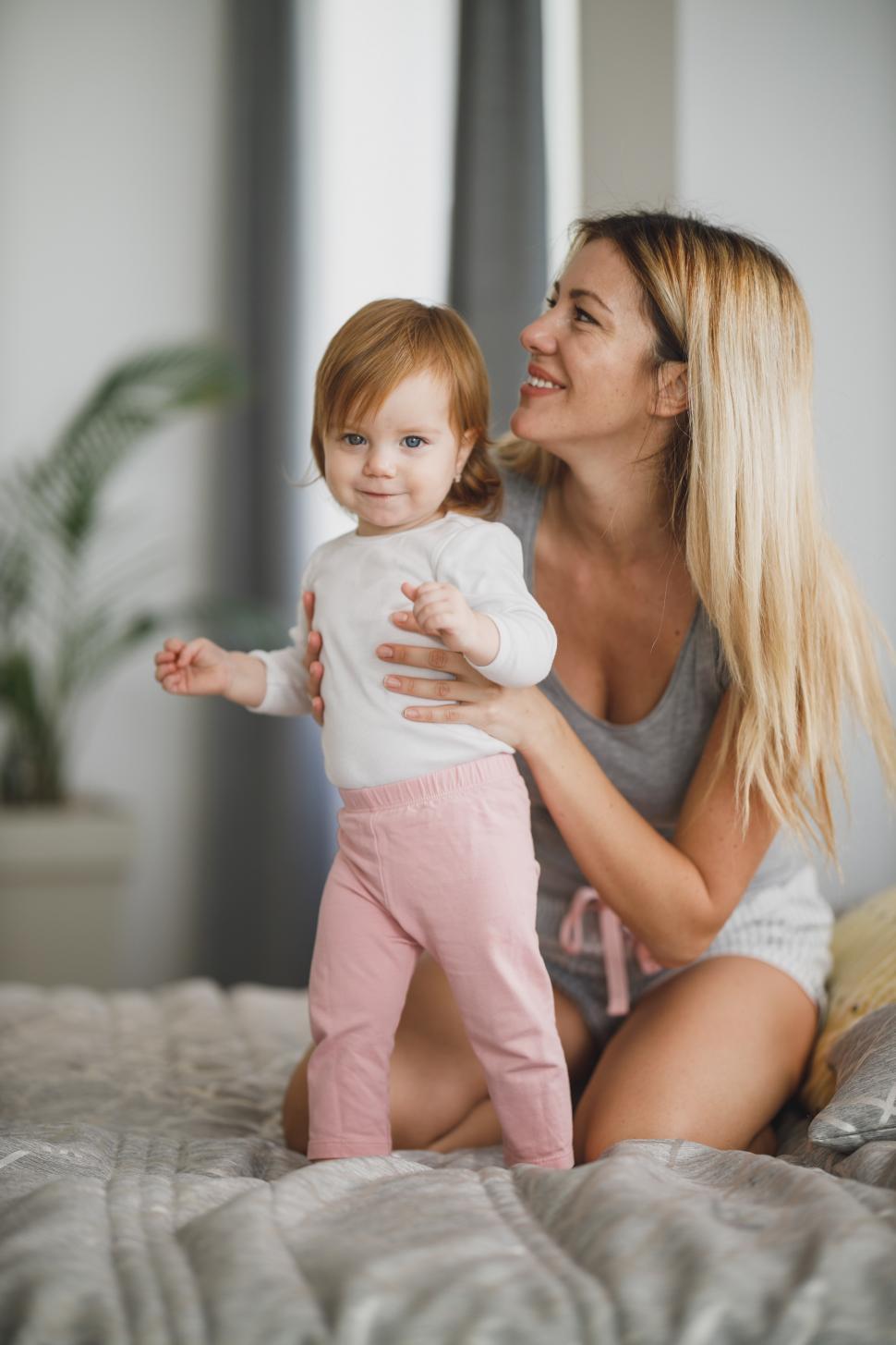 Free Image of Happy mother with her little smiling daughter on bed 