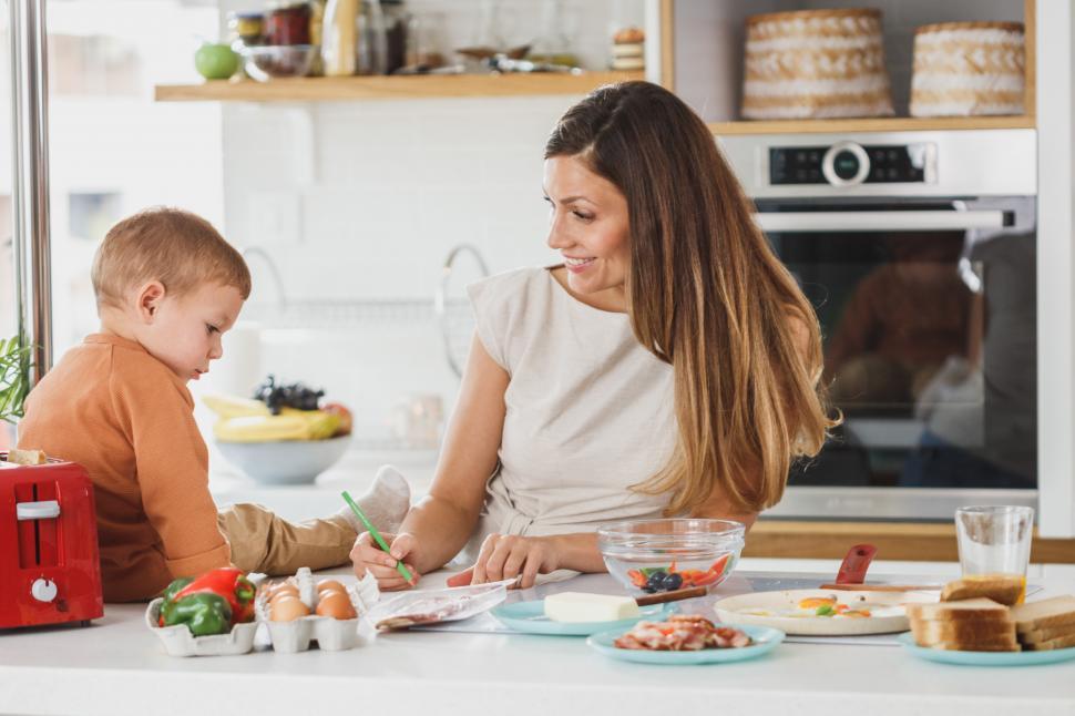 Free Image of Smiling woman helping her son with homework 