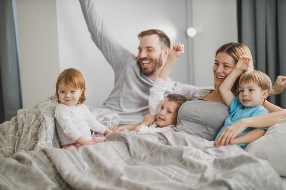 Free Image of Happy Caucasian family with three kids in bed 