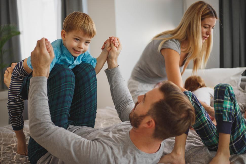 Free Image of Family time. Happy Caucasian family playing on bed 