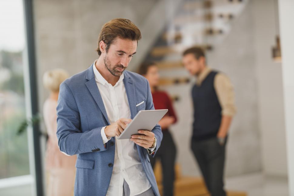 Free Image of Male executive with tablet, standing in the office 