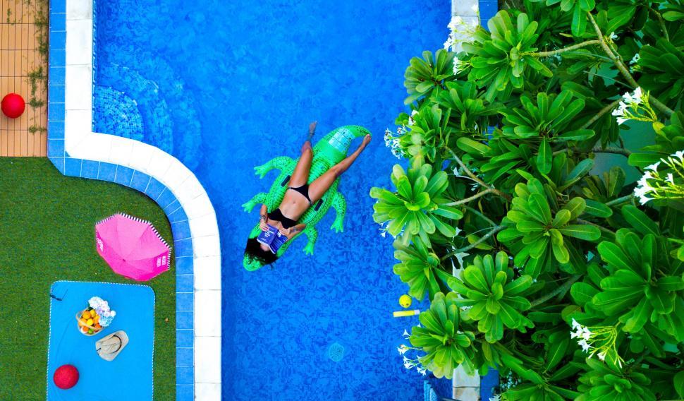 Free Image of Woman with book in pool 