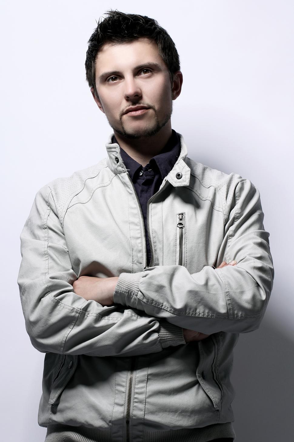 Free Image of Young guy in jacket, arms crossed over chest 