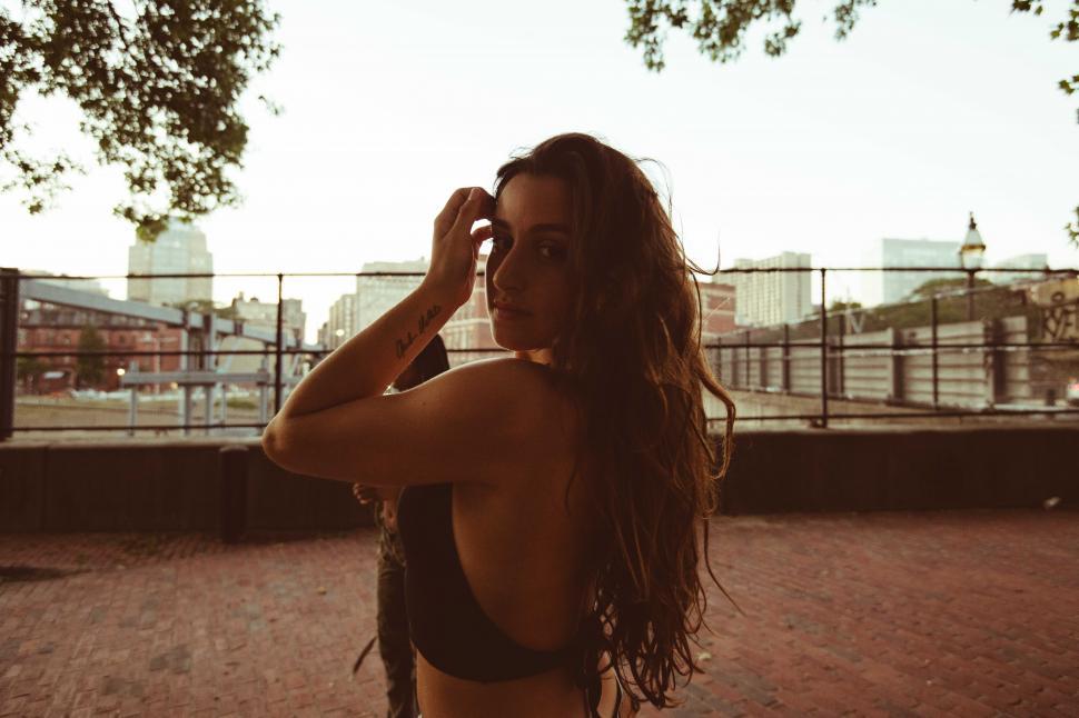 Free Image of Portrait of young woman with long hair in park - looking at came 