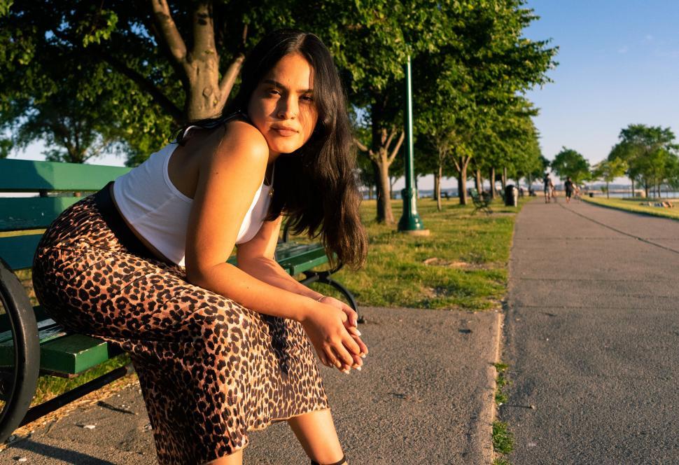 Free Image of Female fashion model with long black hair, sitting and posing in 