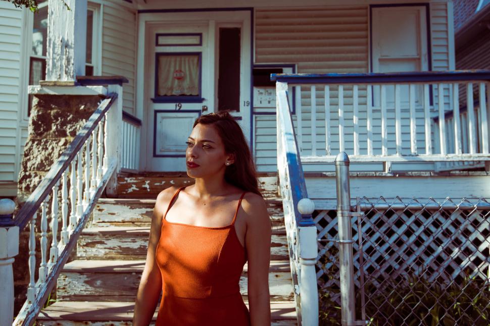 Free Image of Woman standing outside of the house - looking away 