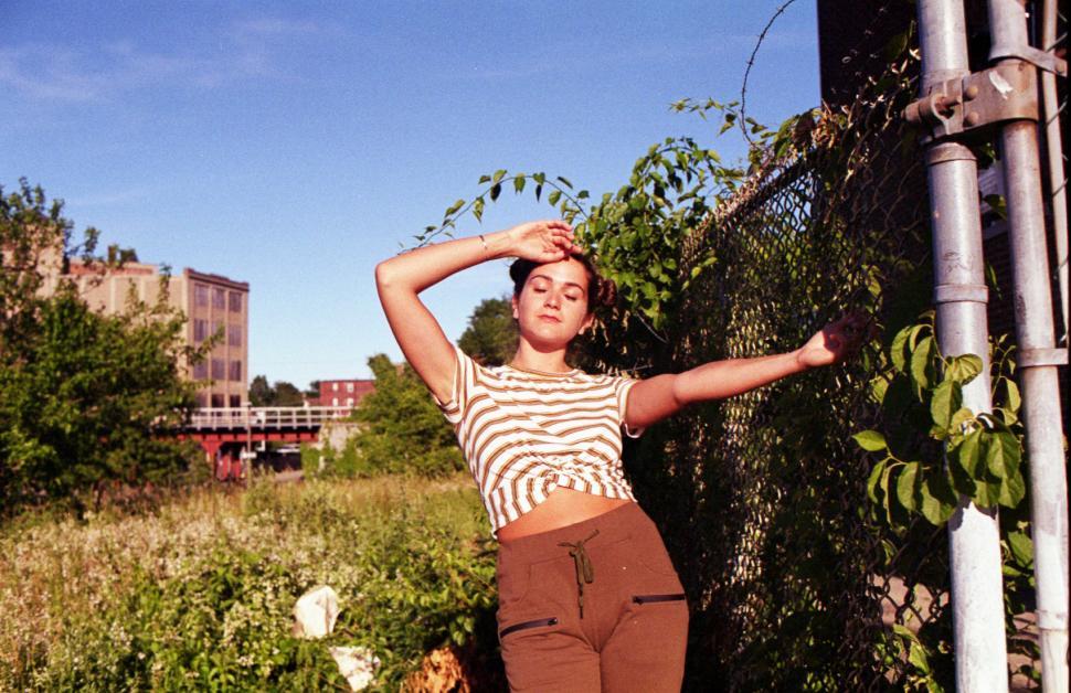 Free Image of Woman posing with fence - eye closed 