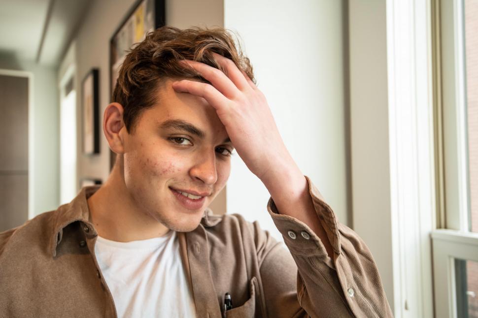 Free Image of Young man touching his head hair 
