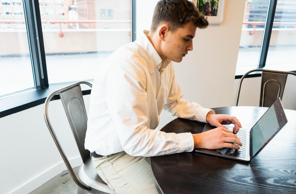 Free Image of Young man working on laptop at the table 