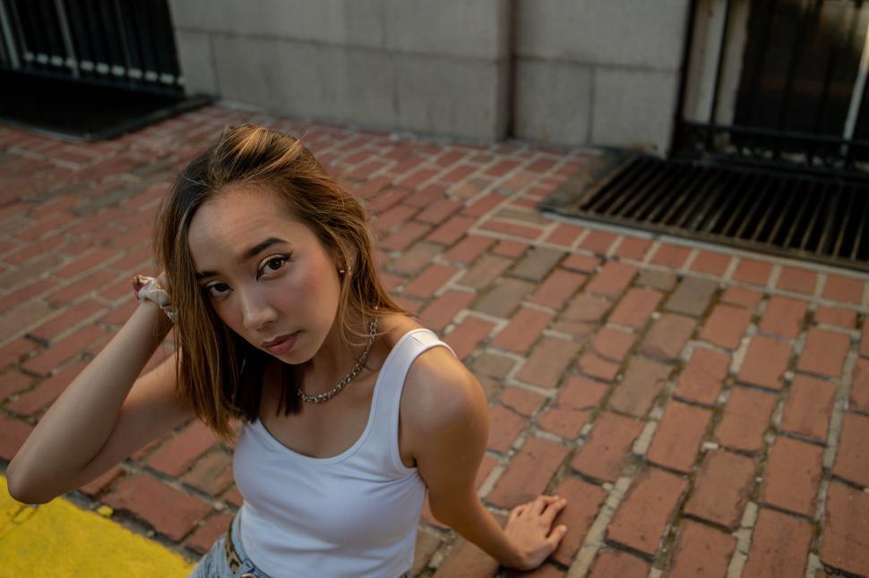 Free Image of Woman sitting on the sidewalk 