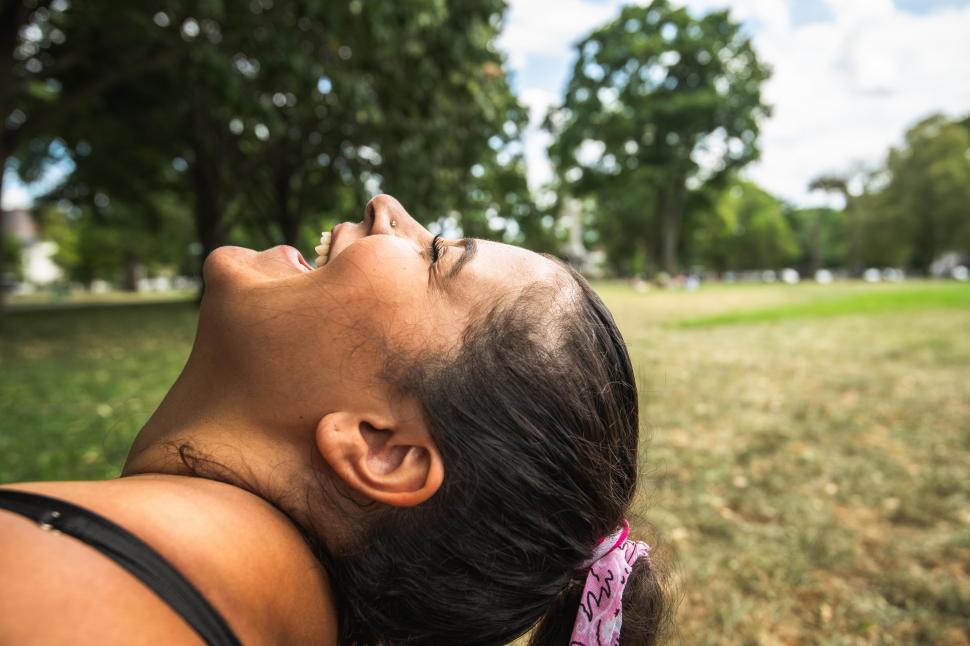Free Image of Side view of woman with toothy smile in the park 