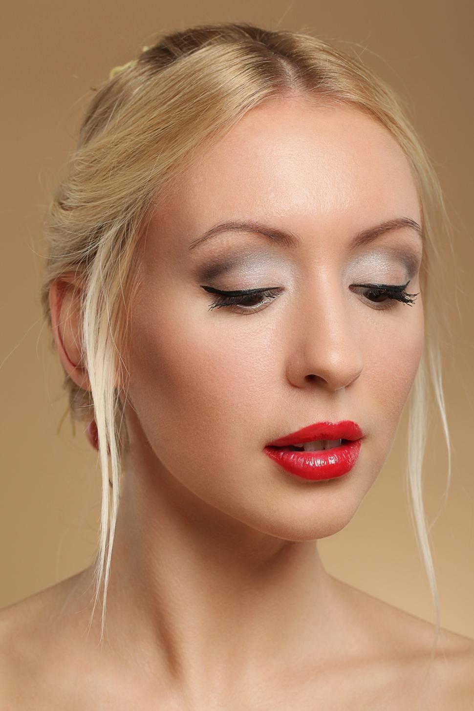 Free Image of Young blonde woman with eyes cast downward 