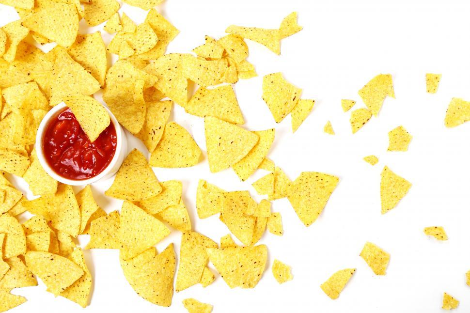 Free Image of Tortilla Chips scattered across a white background 