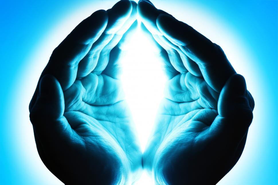 Free Image of Cupped hands in blue light 