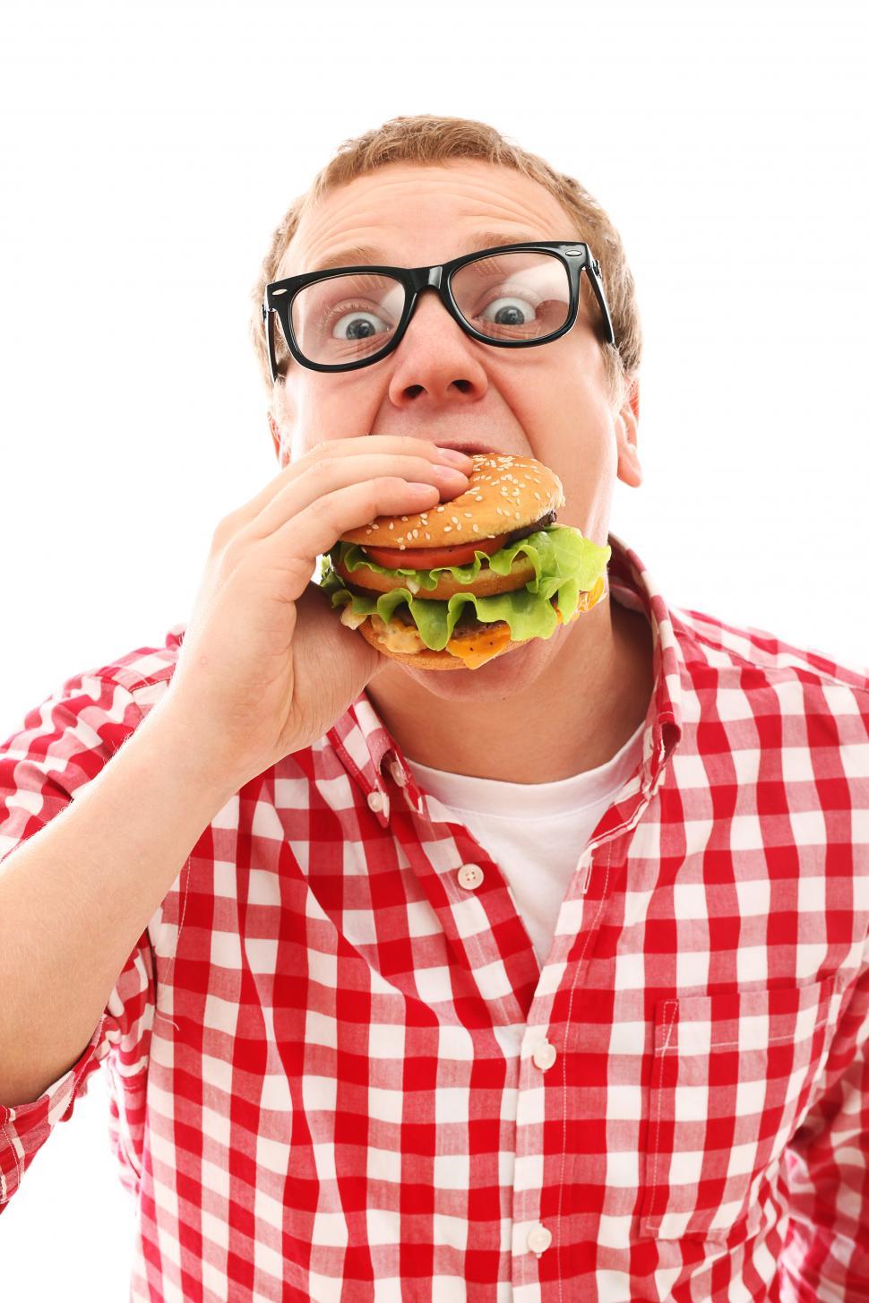 Free Image of Man in plaid attacking a hamburger 