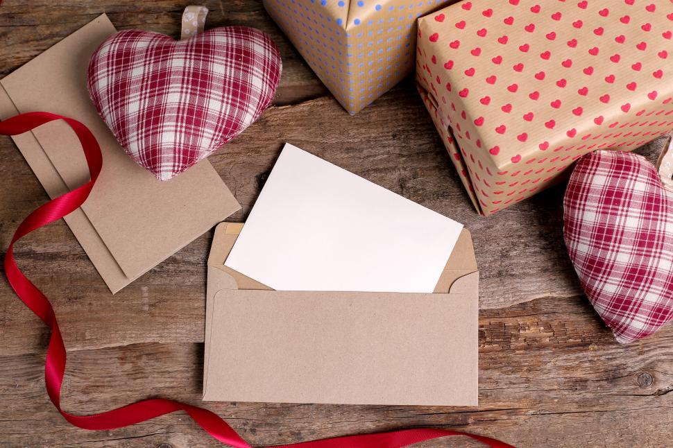 Free Image of Blank holiday card in an envelope, surrounded by gifts 