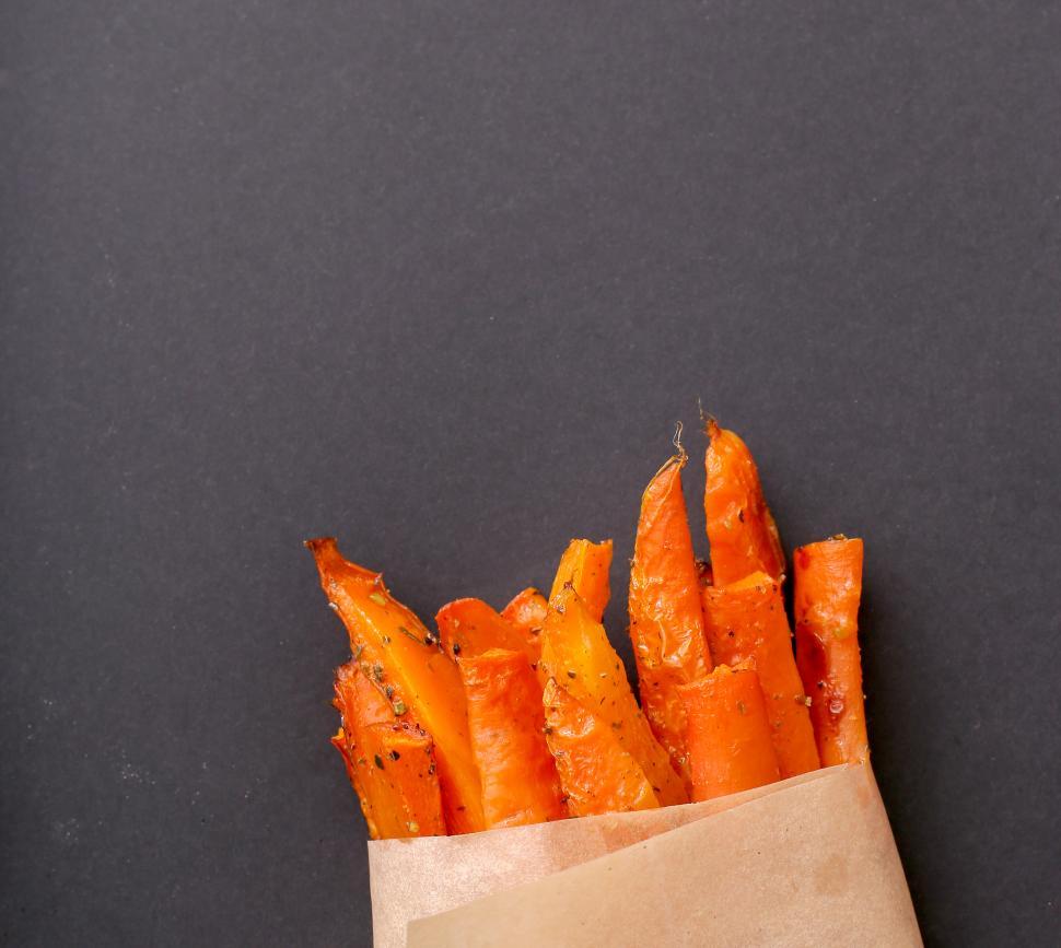 Free Image of French fries peeking out from bag, with copyspace 