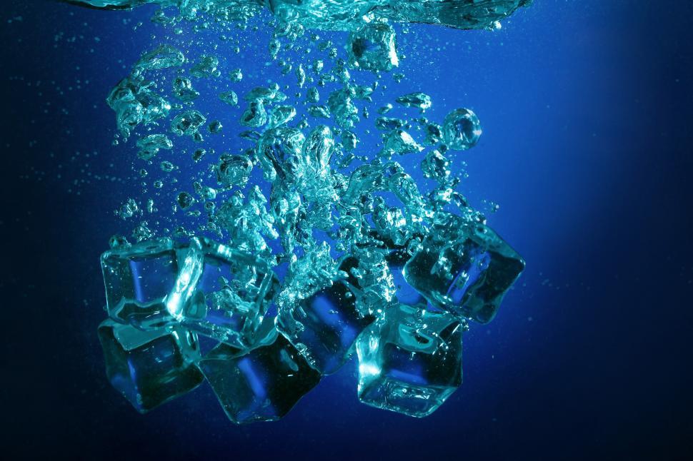 Free Image of Ice cubes falling into water, creating bubbles 