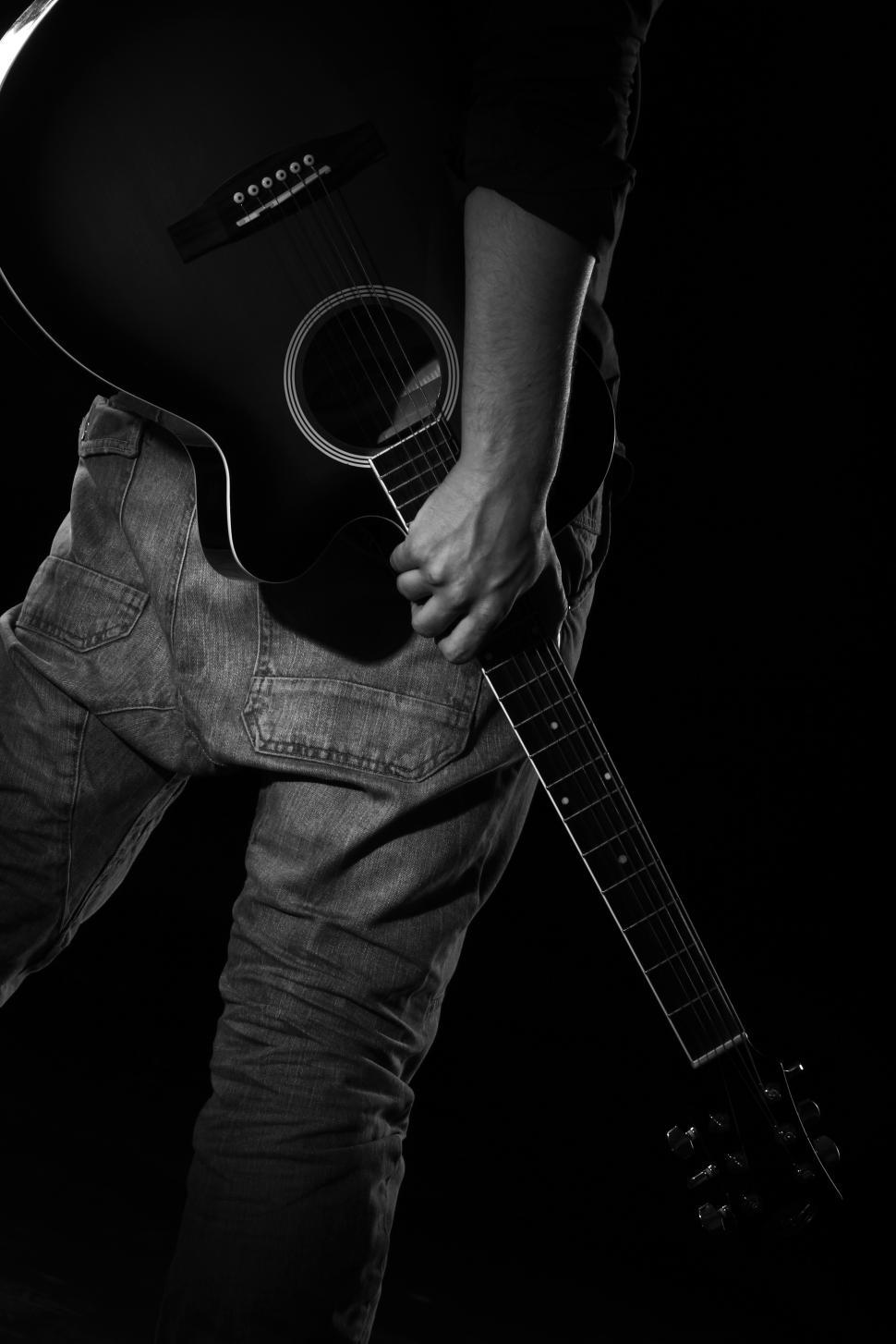 Free Image of Man carrying guitar in darkness 