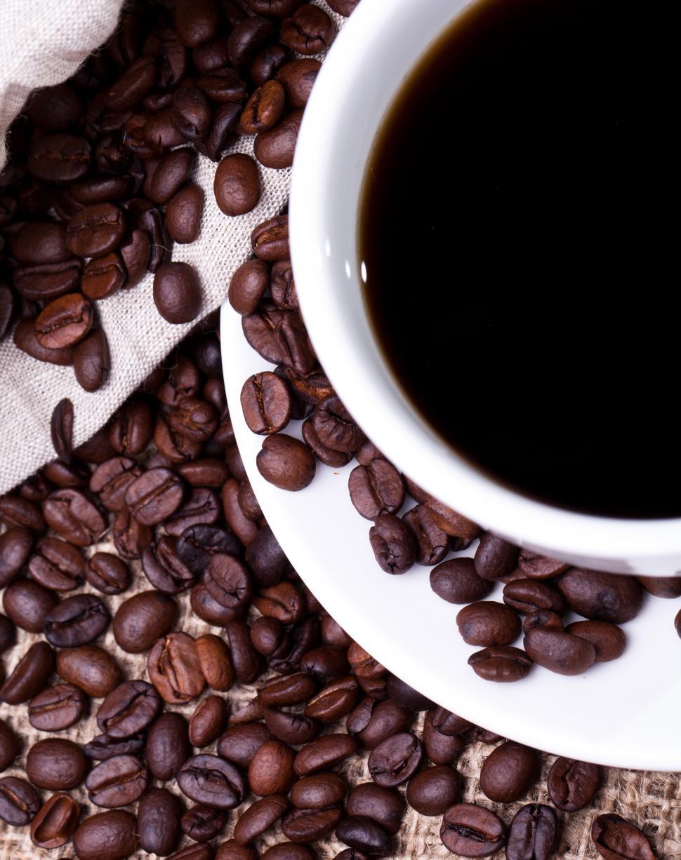 Free Image of Cup of hot coffee, looking down, with whole beans 