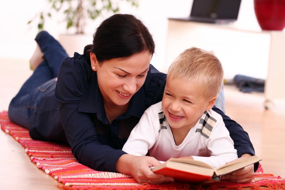 Free Image of Mother on the floor reading book with her child 