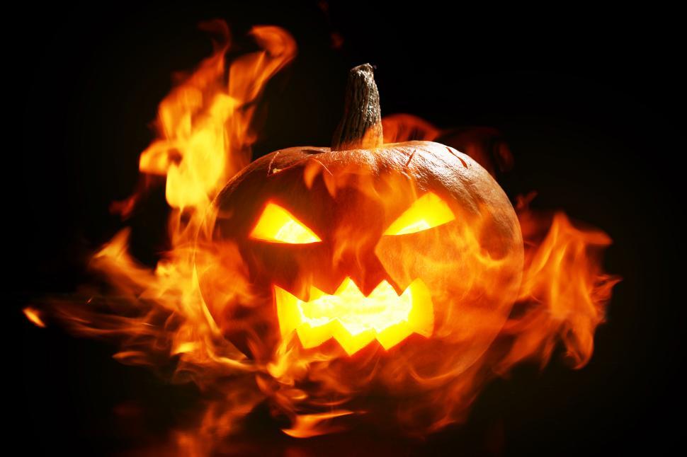 Free Image of Flaming jack o lantern glows in a dark scene 