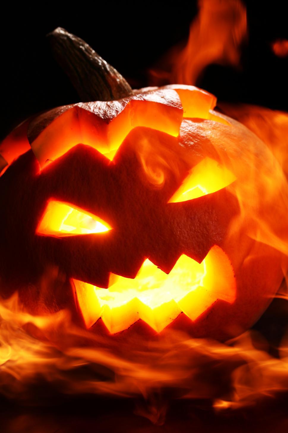 Free Image of Dark scene with bright, flaming jack o lantern 