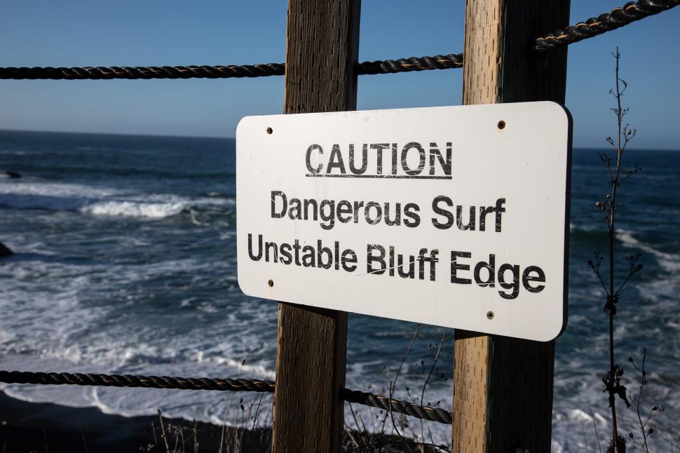 Free Image of Sign warns of Dangerous Surf and Unstable Bluff Edge 