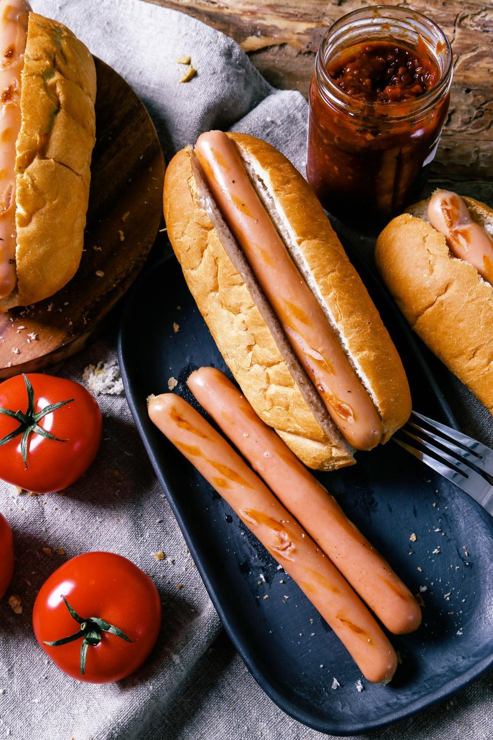 Free Image of Delicious hot dogs with plates and beverage 