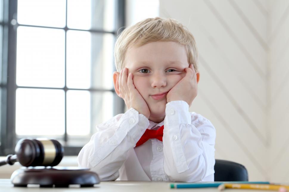 Free Image of Young boy leaning with his face in his hands 