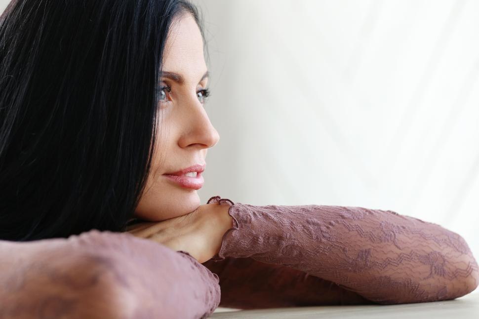 Free Image of Beautiful woman in profile, chin on hands 