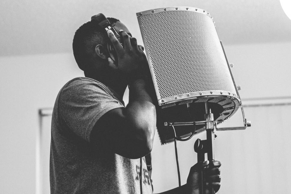 Free Image of Young man with microphone in music studio - b&w 